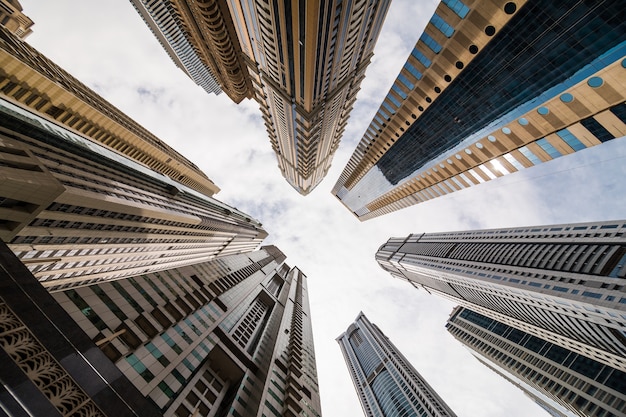 Prospettiva drammatica con vista a basso angolo di grattacieli guardando il cielo, Dubai. Punto di fuga