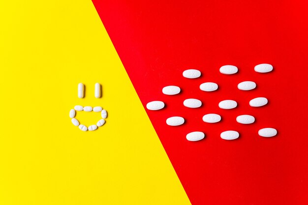 Protezione contro le malattie. Pillole colorate, compresse e capsule sulla parete rossa e gialla - storia del trattamento. Concetto di sanità e medicina, vaccino, prevenzione della pandemia, epidemia.