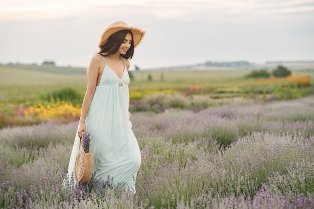 Provenza donna rilassante nel campo di lavanda. Dama con un cappello di paglia. Ragazza con borsa.