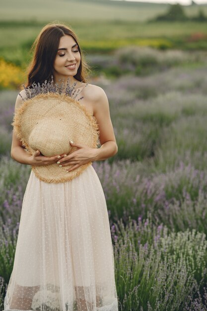 Provenza donna rilassante nel campo di lavanda. Dama con un cappello di paglia.