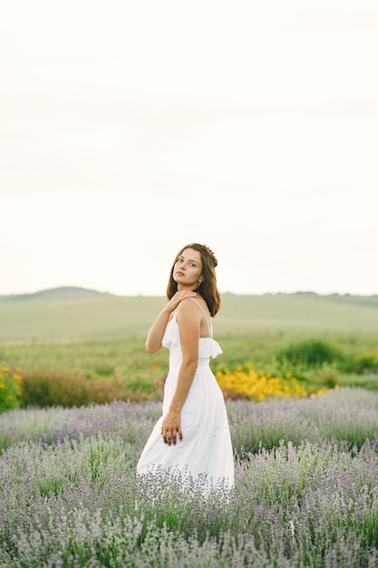 Provenza donna rilassante nel campo di lavanda. Signora in abito bianco. Ragazza con borsa.