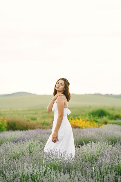 Provenza donna rilassante nel campo di lavanda. Signora in abito bianco. Ragazza con borsa.