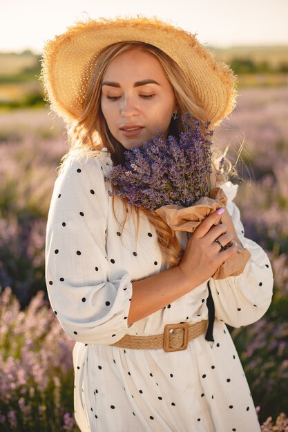 Provenza donna rilassante nel campo di lavanda. Signora in abito bianco. Ragazza con bouquet di fiori.