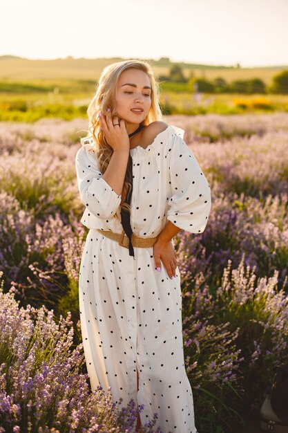 Provenza donna rilassante nel campo di lavanda. Signora in abito bianco. Ragazza con un cappello di paglia.