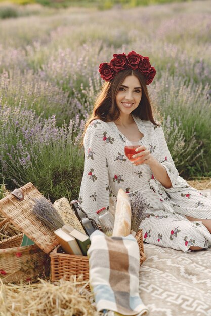 Provenza donna rilassante nel campo di lavanda. Signora in un picnic. Donna in una corona di fiori.