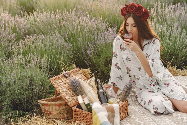 Provenza donna rilassante nel campo di lavanda. Signora in un picnic. Donna in una corona di fiori.