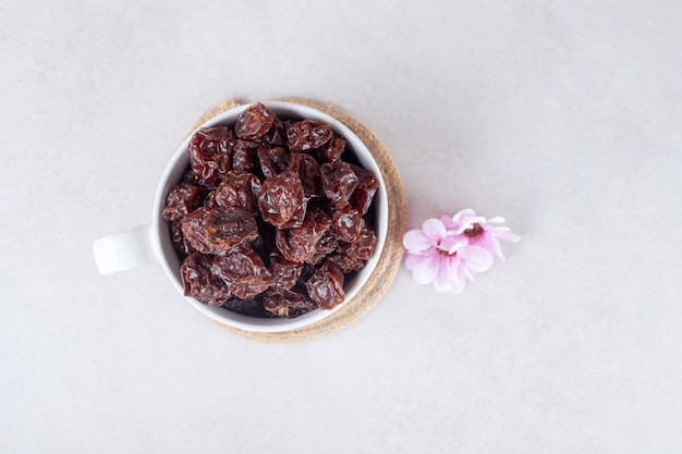 Prugne marroni secche in una tazza o ciotola di ceramica.