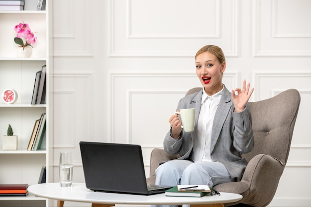 Psicologo che conduce sessioni online carina giovane donna bionda professionale con una tazza di caffè