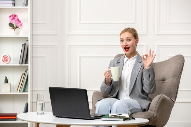 Psicologo che conduce sessioni online carina giovane donna bionda professionale con una tazza di caffè