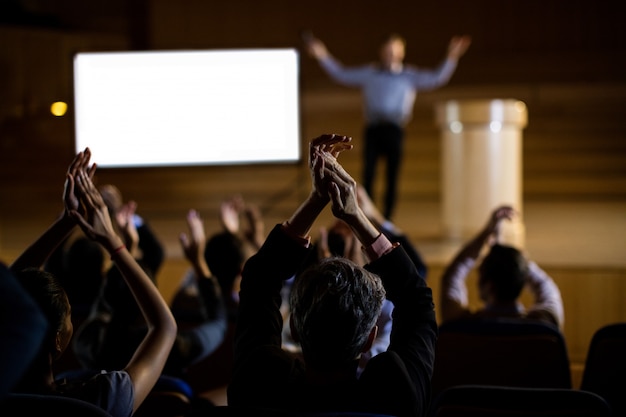 Pubblico che applaude oratore dopo la presentazione della conferenza