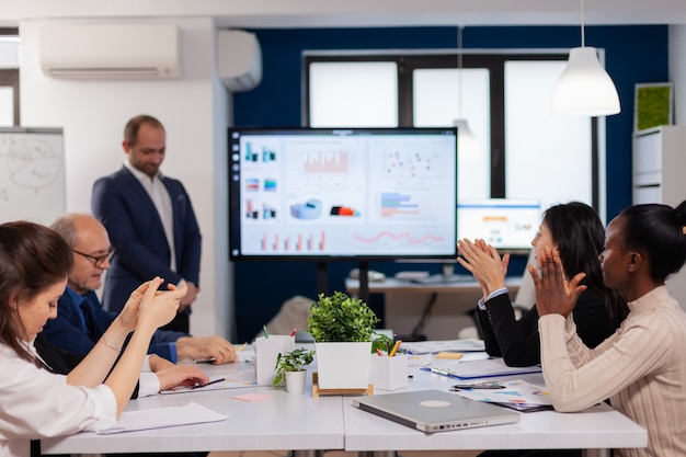 Pubblico sorridente che applaude a un seminario di lavoro dopo la presentazione del divano dell'altoparlante