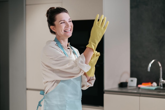 Pulizia. Giovane donna dai capelli scuri che pulisce in cucina