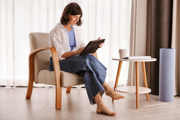 Punto di vista completo della donna di affari che si siede nella sedia nella stanza