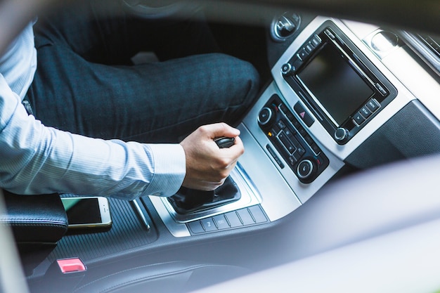 Punto di vista dell&#39;angolo alto della mano di un uomo che cambia marcia in automobile