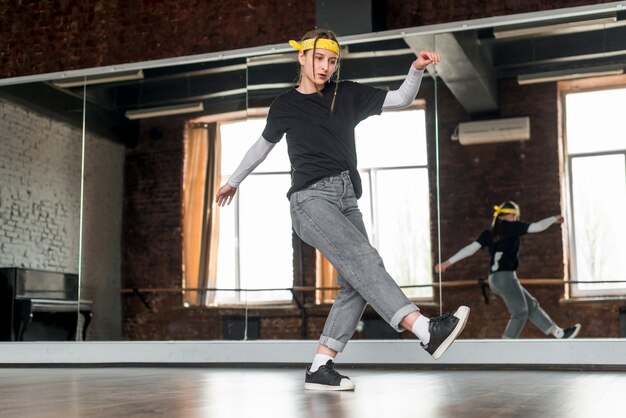 Punto di vista di angolo basso del ballerino femminile che balla nello studio