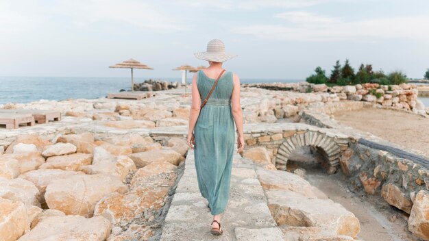 Punto di vista di Bach della donna turistica senior alla spiaggia