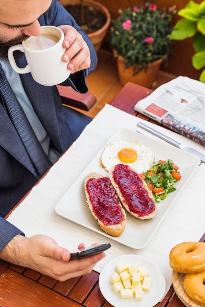 Punto di vista elevato di un tè bevente dell&#39;uomo in ristorante