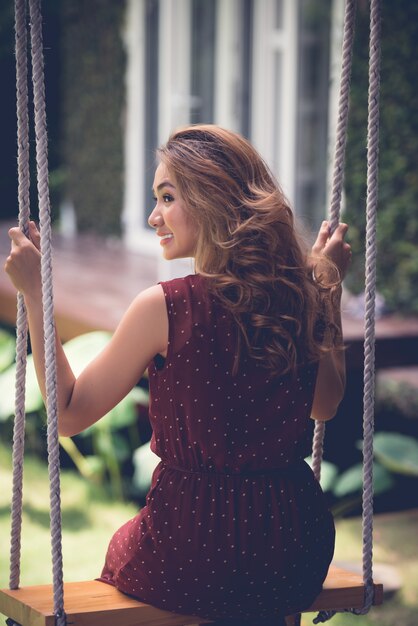 Punto di vista posteriore della donna con bei capelli ondulati che oscillano nel cortile