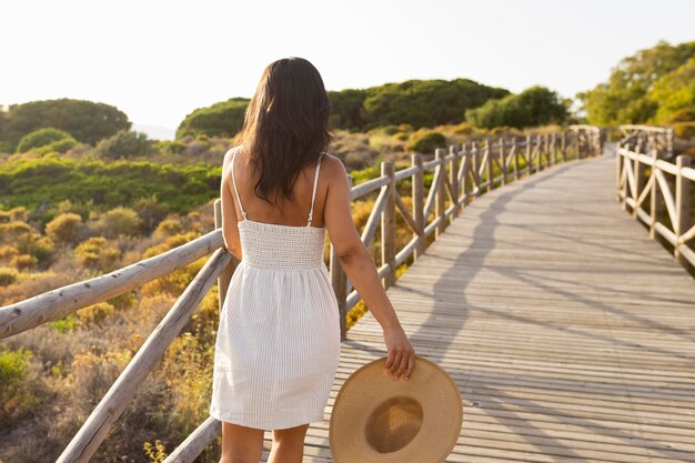 Punto di vista posteriore della donna in natura con il cappello