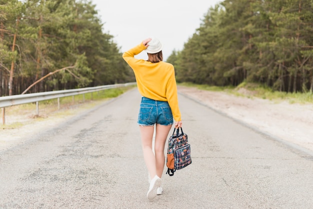 Punto di vista posteriore della donna itinerante sulla strada