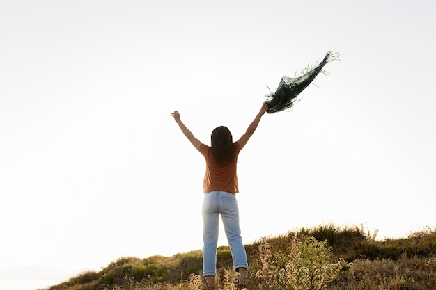 Punto di vista posteriore della donna spensierata in natura