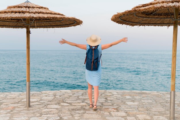 Punto di vista posteriore della donna turistica con gli ombrelloni