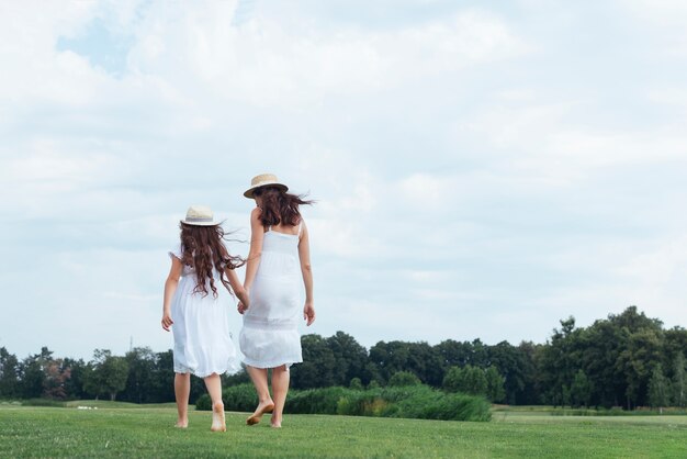 Punto di vista posteriore madre e figlia che camminano all&#39;aperto