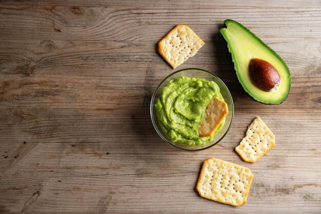 Purè di salsa guacamole di avocado in una ciotola con cracker