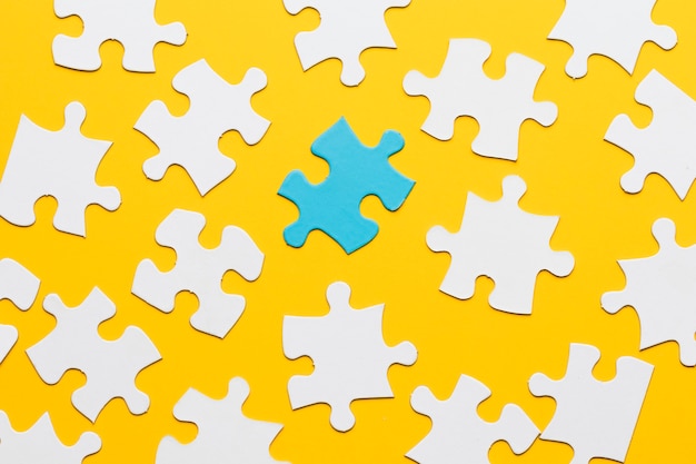 Puzzle blu con pezzo di puzzle bianco su sfondo giallo