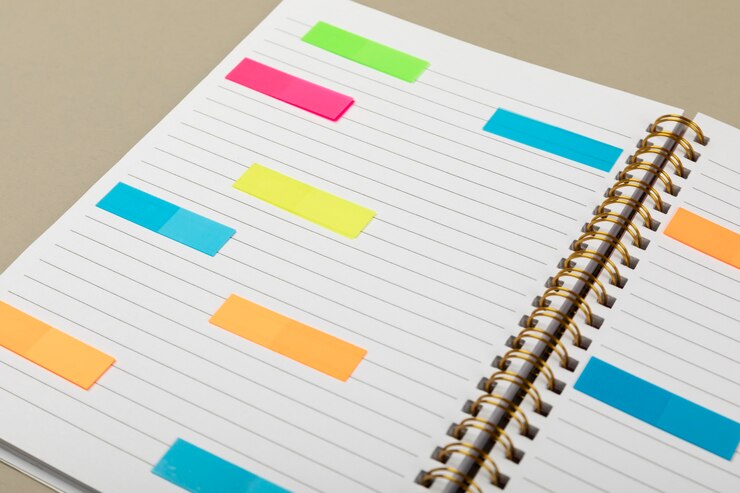 Foto gratuito quaderno ad alto angolo con post-it colorati