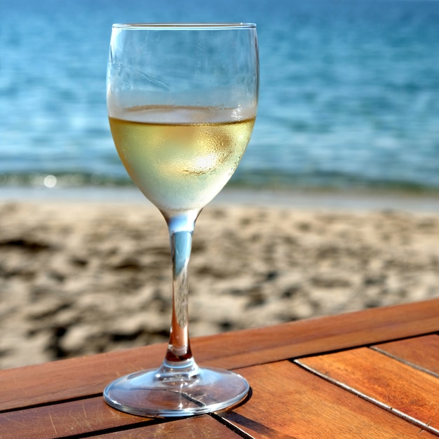 Quadrato mediterraneo della tavola della spiaggia del vino bianco freddo di vetro