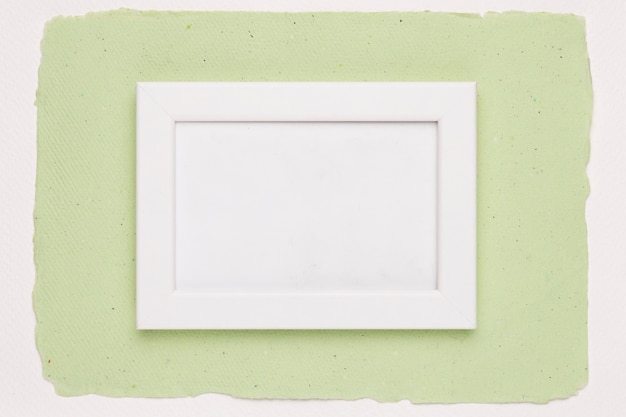 Quadro bianco vuoto su sfondo di carta verde