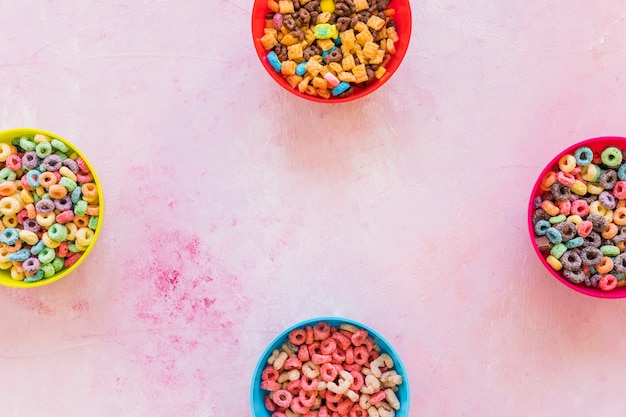 Quattro ciotole con cereali sul tavolo rosa