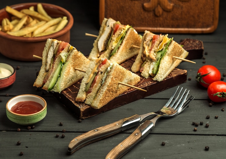 Foto gratuito quattro piccole porzioni di panino di pollo su spilli di bambù
