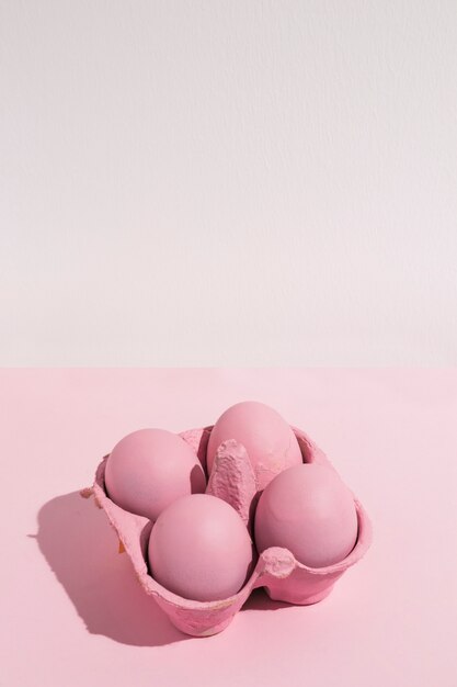 Quattro uova di Pasqua rosa in rack sul tavolo luminoso