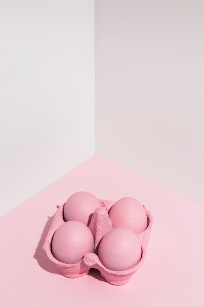 Quattro uova di Pasqua rosa in rack sul tavolo