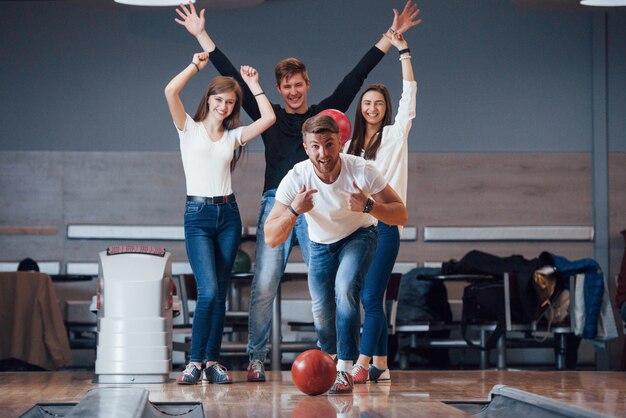 Questa è una vittoria. I giovani amici allegri si divertono al bowling durante i fine settimana