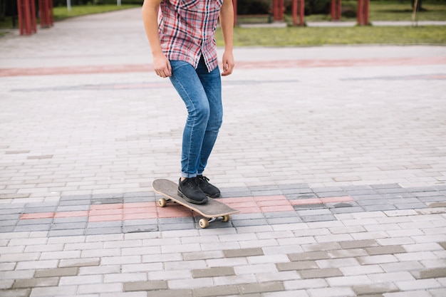 Raccolga l&#39;adolescente che skateboarding sulla pavimentazione del parco