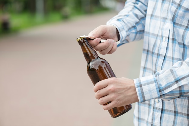 Raccolga l&#39;uomo che apre la birra in bar