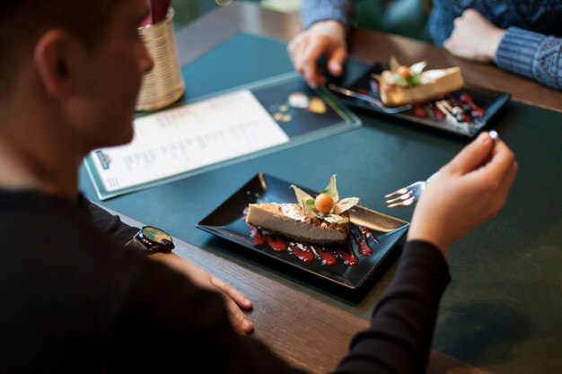 Raccolga l&#39;uomo che mangia il dessert in caffè