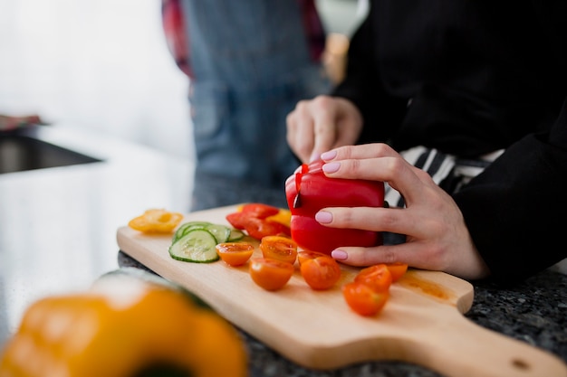 Raccolga la donna che affetta il pepe per insalata