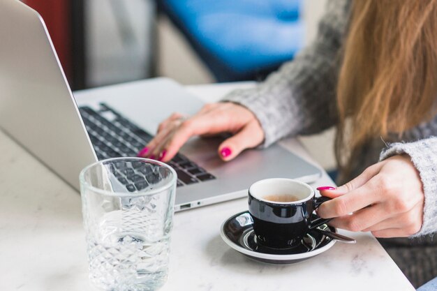 Raccolga la donna che lavora al computer portatile