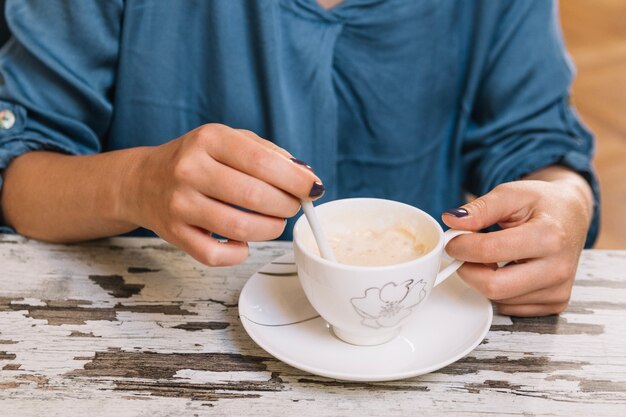 Raccolga la donna che mescola il caffè