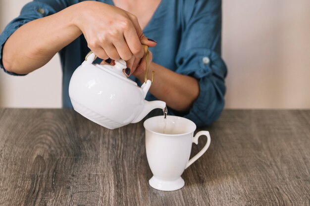 Raccolga la donna che versa il tè