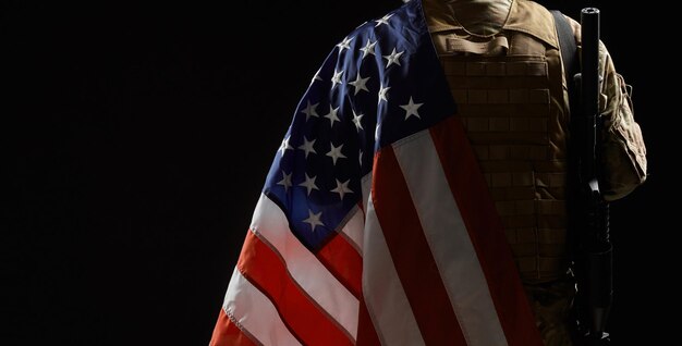 Raccolto di soldato americano con bandiera e fucile