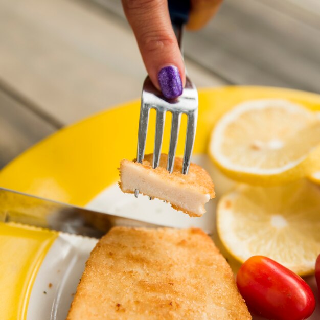 Raccolto femmina prendendo pollo dal piatto