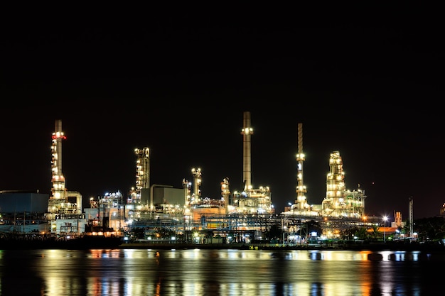 Raffineria di petrolio di notte con riflessione