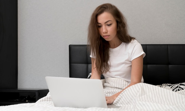 Ragazza a letto con il portatile