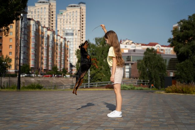 Ragazza a tutto campo che gioca con il cane