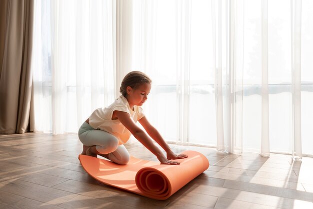 Ragazza a tutto campo con tappetino da yoga